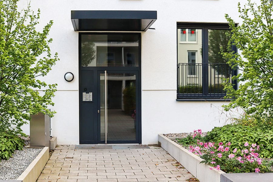 Dunkle Haustür mit Glaseinsatz als Eingang eines modernen Wohnhauses